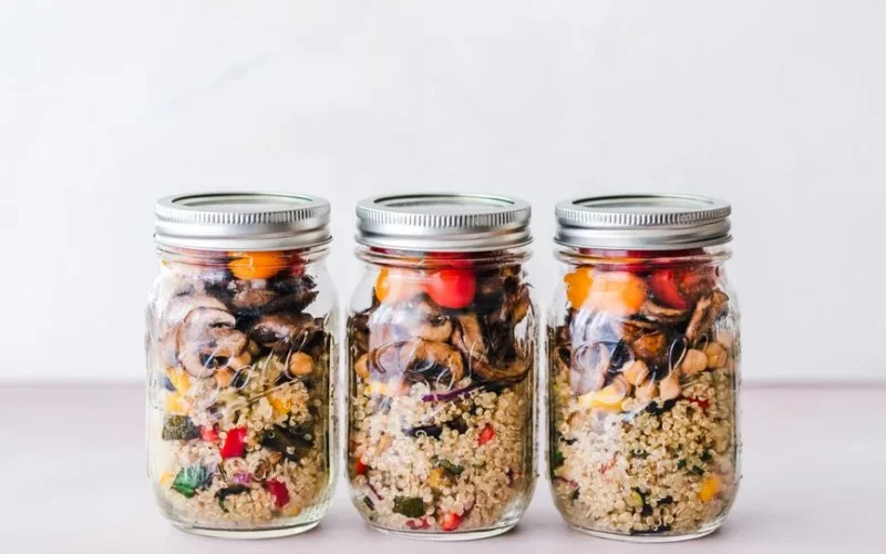 Colorful quinoa salad jar with roasted veggies, ideal for healthy meal prep.