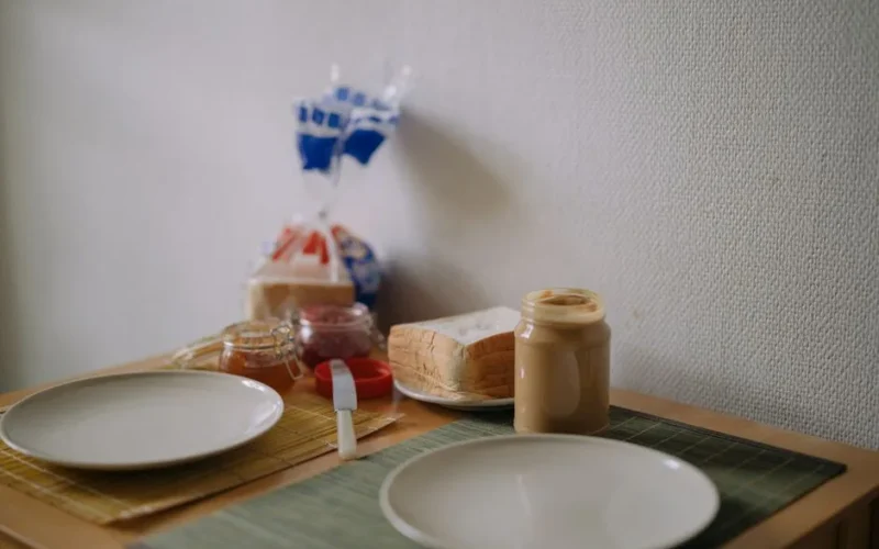 Inviting breakfast table setup with bread and peanut butter, ready for a cozy meal.