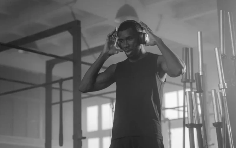 Monochrome photo of a man wearing headphones in a gym. Ideal for fitness and lifestyle themes.