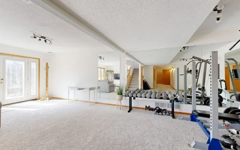 Bright home gym setup with weights, mirrors, and modern decor.