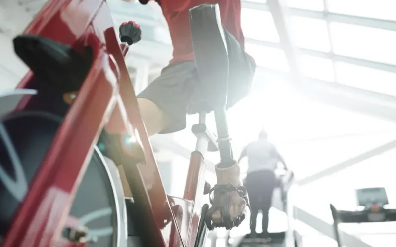 Motivated athlete with prosthetic leg working out on a stationary bike, demonstrating strength and resilience.