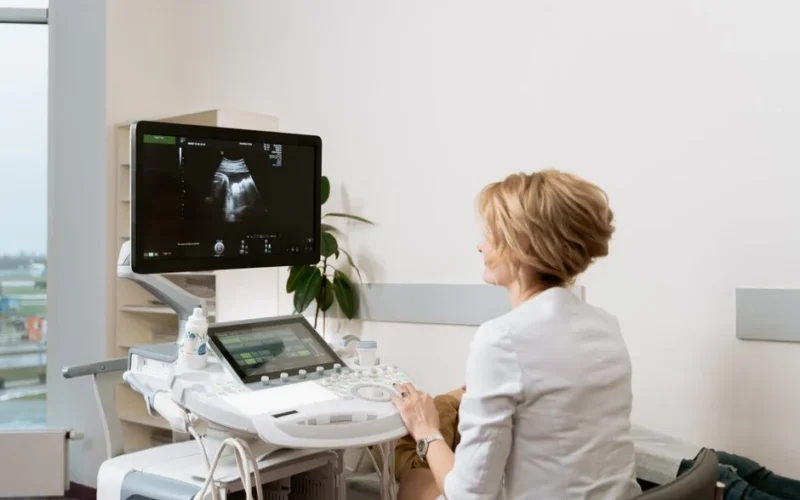A healthcare professional conducting an ultrasound scan in a clinic setting.