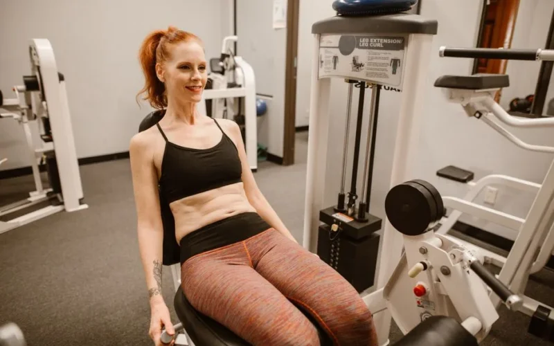 Woman performing leg workout in gym, showcasing fitness and health lifestyle.