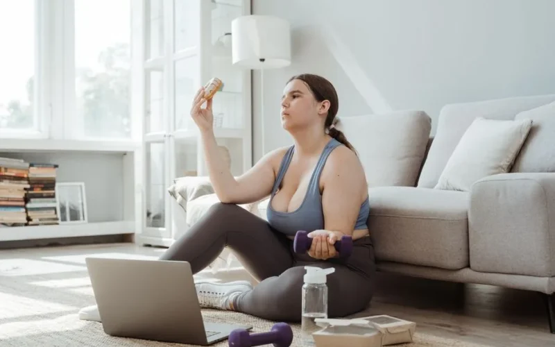 Plus-size woman exercising and making healthy choices in a cozy living room.