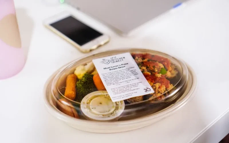 A packaged meal in a plastic container featuring fresh vegetables, ideal for healthy eating concepts.