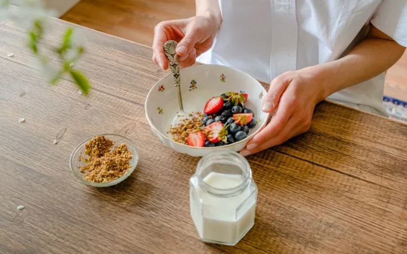 A vibrant homemade yogurt bowl with strawberries, blueberries, and crushed nuts, perfect for a healthy breakfast.