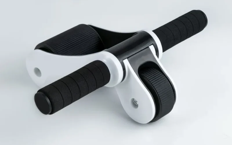 Close-up of a dual wheel ab roller with black handles on a white background, ideal for fitness routines.