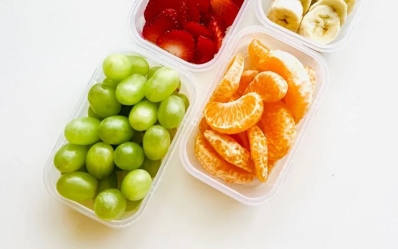 Bright and fresh fruits in containers, ideal for a healthy snack or meal prep.