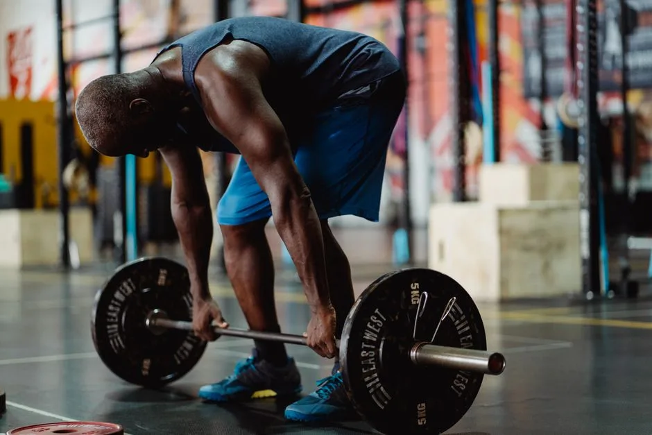 Man performing deadlifts in a modern gym, showcasing strength and fitness.