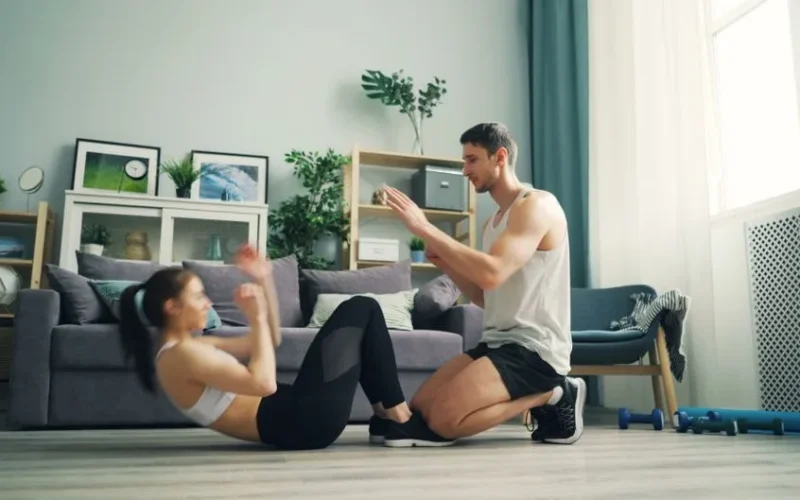 A couple exercising together at home with sit-ups and motivation.