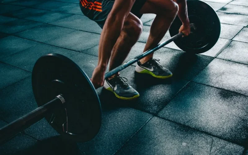 Man performing a deadlift exercise in a gym, demonstrating strength and fitness.