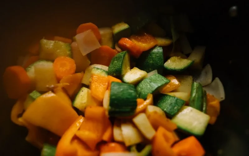 Close-up of sliced vegetables including zucchini, carrots, and peppers for a colorful and healthy dish.