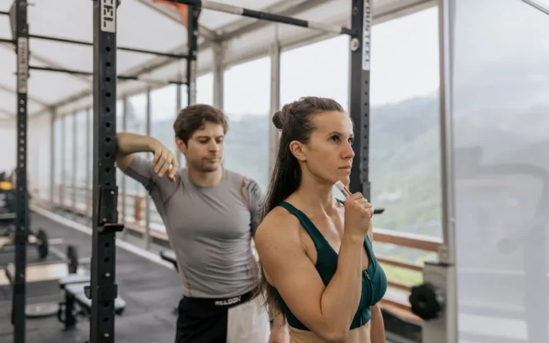 A fit couple engaged in gym exercises. Indoor workout with focus on fitness goals.