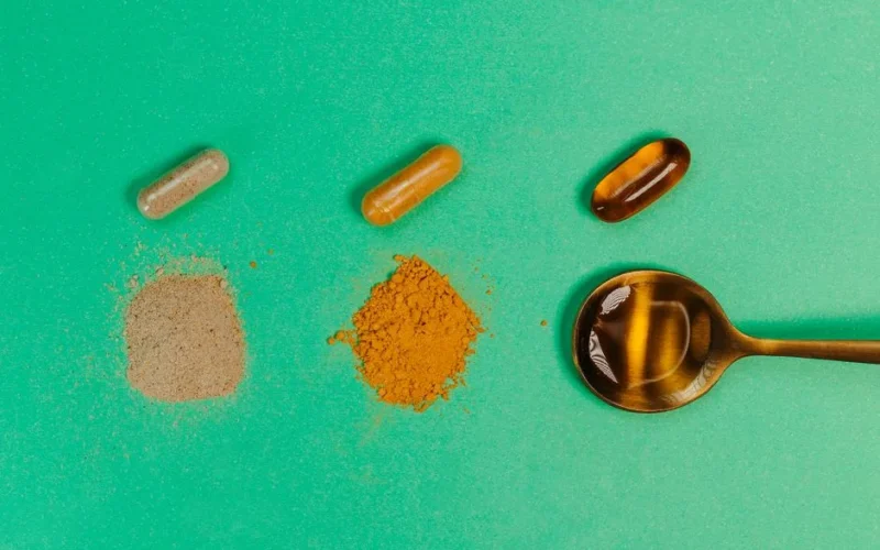 Various nutritional supplements and powders displayed with a spoon on a green background.