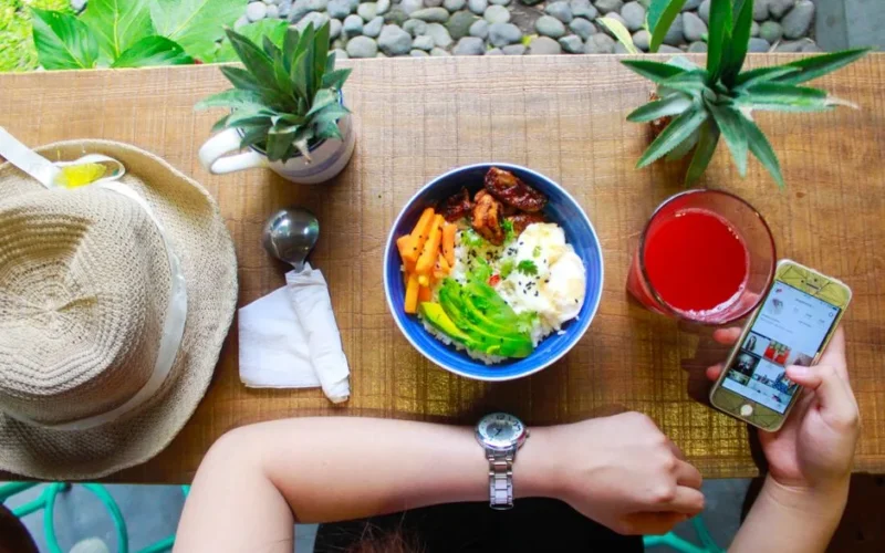 Fresh and healthy bowl meal with juice and smartphone on a wooden table, perfect for lifestyle and food photography.