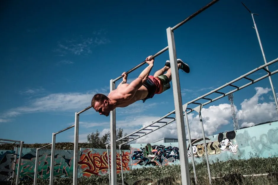 An athletic man doing a flag pose on outdoor gym bars with a graffiti wall backdrop.