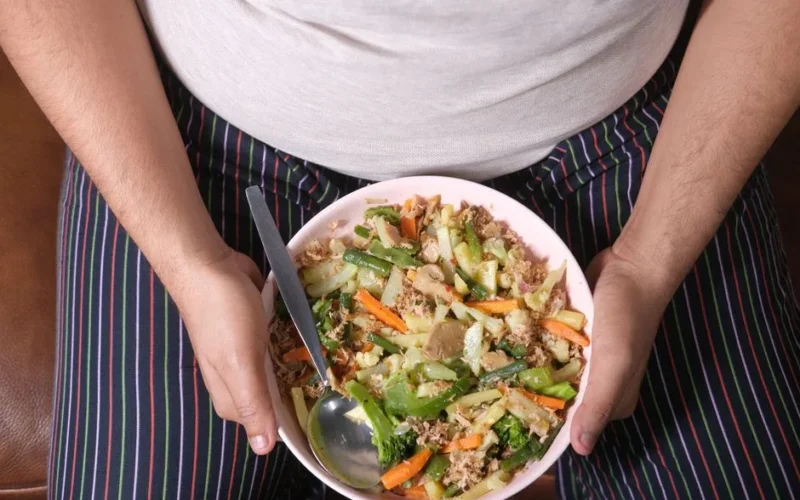 Close-up of a person holding a bowl of mixed vegetables, representing a healthy lifestyle.