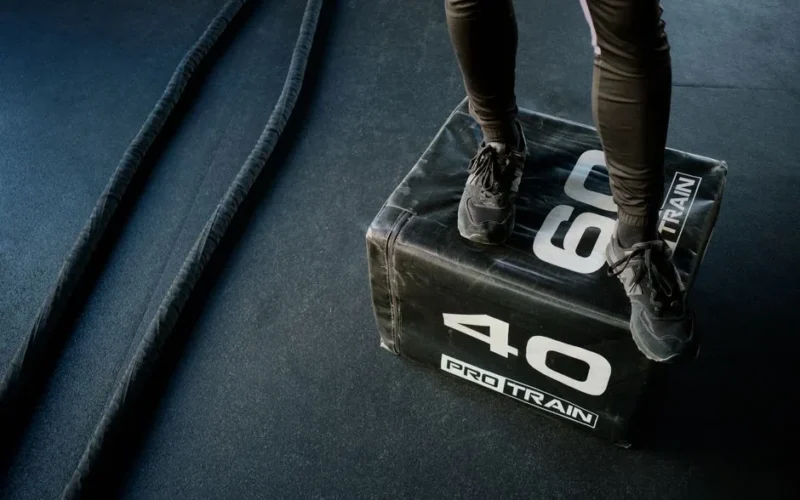 Engage in high-intensity gym workout using battle ropes and a sturdy plyo box for cardio and strength.